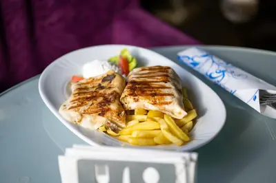 a plate of fish and french fries on a table at Motel Celebic in Podgorica