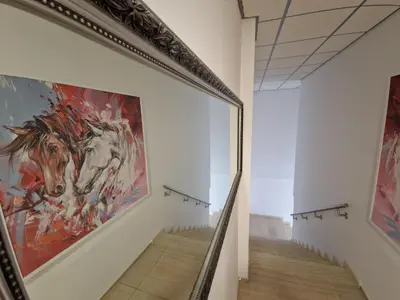 a mirror in a hallway with a painting of a horse at Motel Celebic in Podgorica