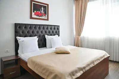 a bedroom with a large bed with a black headboard at Motel Celebic in Podgorica