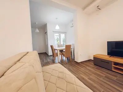 a living room with a couch and a tv and a table at Mialex apartments in Dobra Voda