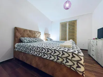 a bedroom with a large bed with a brown headboard at Mialex apartments in Dobra Voda