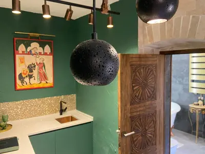 a kitchen with a green wall and a hanging light at La Mia Amore in Kotor