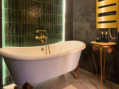 a bath tub in a bathroom with green tiles at La Mia Amore in Kotor