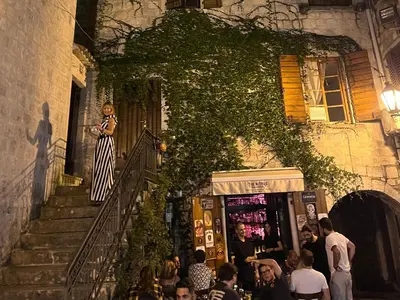 a woman standing on the stairs of a building at La Mia Amore in Kotor