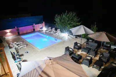 an overhead view of a swimming pool with chairs and umbrellas at Apartman Sedmica in Danilovgrad