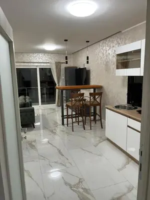 a kitchen with a table and chairs on a marble floor at Cezar Apartments in Podgorica