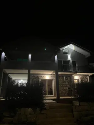 a house with lights on the front of it at night at Cezar Apartments in Podgorica