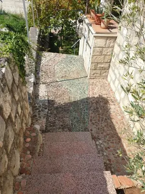 a stone walkway with a shadow on a wall at Villa Frida in Sveti Stefan
