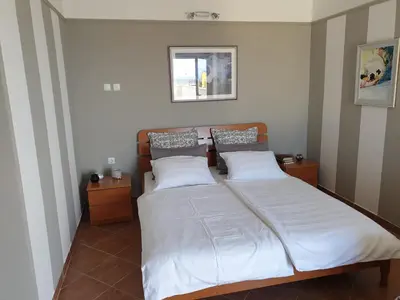a bedroom with a large bed with white sheets at Villa Frida in Sveti Stefan