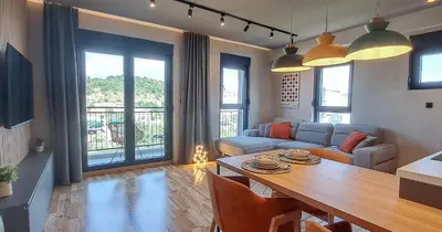 a living room with a table and a couch at Stylish One Bedroom Apartment in Podgorica