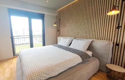 a bedroom with a bed and a couch and a window at Stylish One Bedroom Apartment in Podgorica