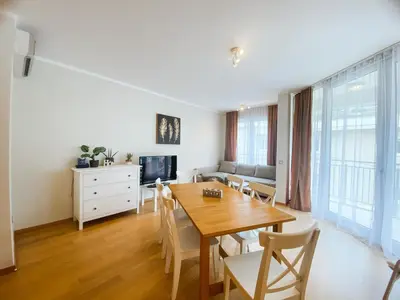 a dining room with a wooden table and chairs at Sunny apartment in Becici