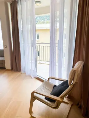 a chair sitting in front of a window with a view at Sunny apartment in Becici