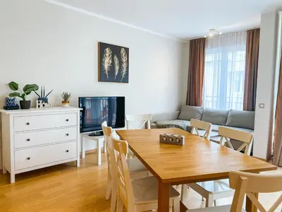 a living room with a wooden table and a couch at Sunny apartment in Becici