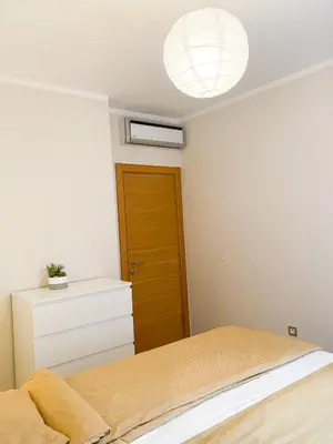a bedroom with a bed and a light fixture at Sunny apartment in Becici