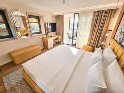 a bedroom with a large white bed in a room at The New Hotel Mediteran - VILLA Edition in Ulcinj