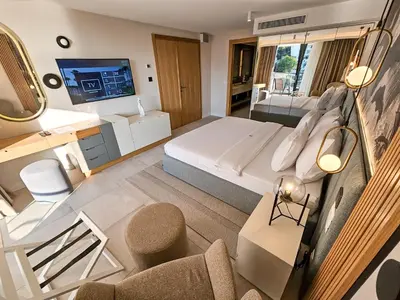 a hotel room with a large bed and a tv at The New Hotel Mediteran - VILLA Edition in Ulcinj