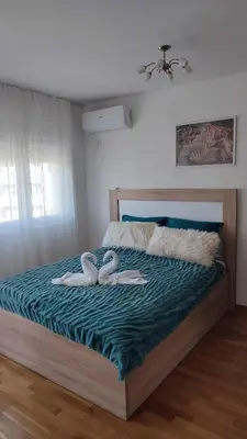 a bedroom with two swans towels on a bed at Apartmani Stari Aerodrom in Podgorica