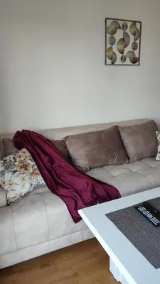a blanket sitting on a couch in a living room at Apartmani Stari Aerodrom in Podgorica
