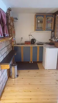 a kitchen with a counter and a refrigerator in a room at Cute lodge in Zeta in Mahala