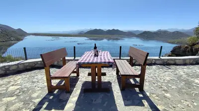 a table with a bottle of wine sitting on top of it at Bobija Village Skadar lake in Karuč