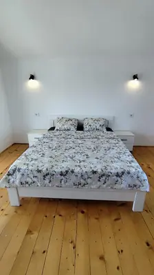 a bedroom with a large bed with a wooden floor at Bobija Village Skadar lake in Karuč