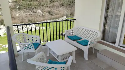 a balcony with two chairs and a table and a window at Bobija Village Skadar lake in Karuč