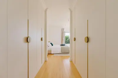 a hallway with white doors leading to a bedroom at Vila Bellevue in Budva