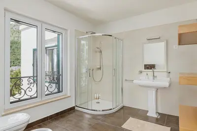 a bathroom with a shower and a toilet and a sink at Vila Bellevue in Budva