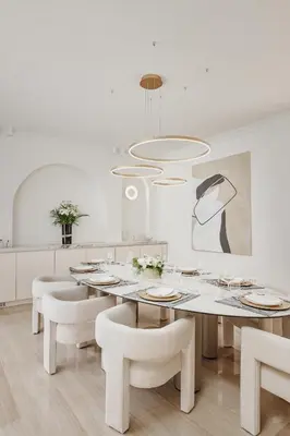 a white dining room with a table and chairs at Vila Bellevue in Budva