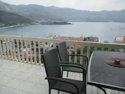 a balcony with a table and chairs and a view of the water at TOP view Apartment Budva in Budva