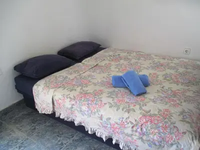 a bed with a blue cross on top of it at TOP view Apartment Budva in Budva