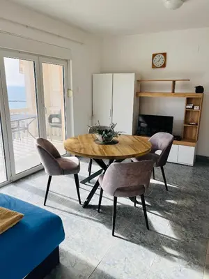 a dining room with a wooden table and chairs at TOP view Apartment Budva in Budva