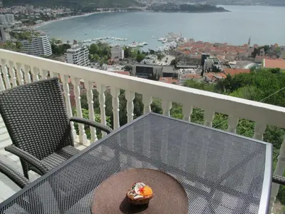 a table with a plate of food on a balcony at TOP view Apartment Budva in Budva