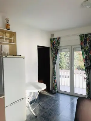 a kitchen with a table and a white refrigerator at TOP view Apartment Budva in Budva