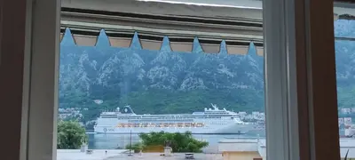 a cruise ship in the water viewed from a window at Apartment OAZA in Kotor