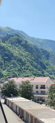 a large building with a mountain in the background at Apartment OAZA in Kotor