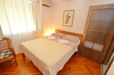 a small bedroom with a bed and a window at Apartment OAZA in Kotor
