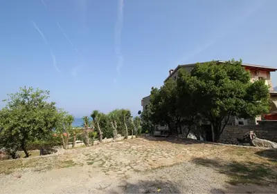 a house with trees on the side of a dirt road at STONE HOUSE “MEDITERRANEO” in Bar