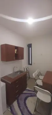 a room with a sink and chairs and a table at Apartament Mehmeti in Ulcinj