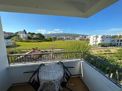 a balcony with a table and a view of a field at Apartments Near The Coast - Milla in Ulcinj
