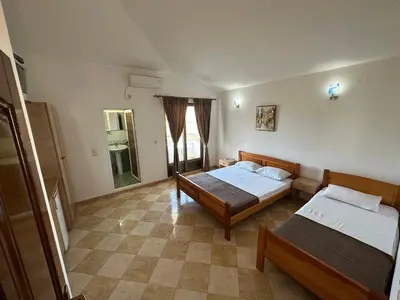a room with two beds and a table in it at Apartments Near The Coast - Milla in Ulcinj