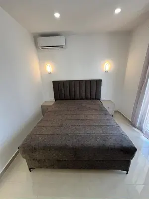 a bedroom with a bed in a room with two lights at Apartments Bojku in Ulcinj
