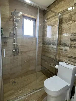 a bathroom with a toilet and a glass shower at Apartments Bojku in Ulcinj