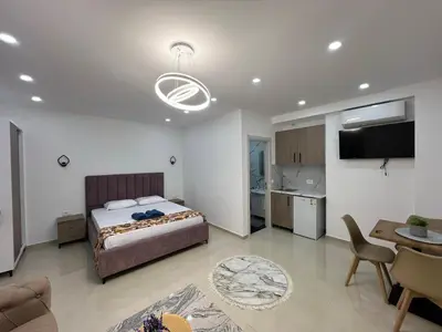 a bedroom with a bed and a living room at Apartments Bojku in Ulcinj