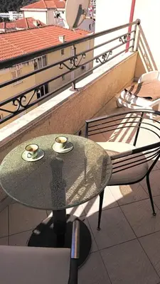 a glass table with two cups on top of a balcony at Nossa Casa in Becici