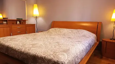 a bedroom with a bed with two lamps and a dresser at Nossa Casa in Becici