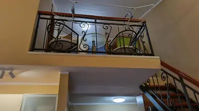 a staircase with a wrought iron balcony with chairs at Nossa Casa in Becici