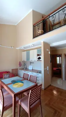 a kitchen and dining room with a table and chairs at Nossa Casa in Becici