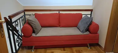 a red couch with two pillows on a staircase at Nossa Casa in Becici